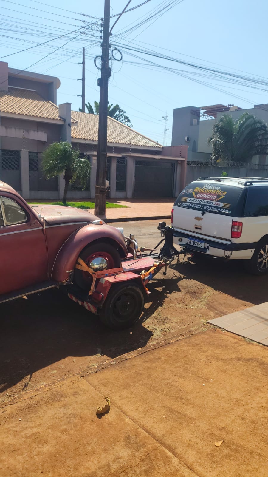 Fusca clássico sendo rebocado com asa-delta